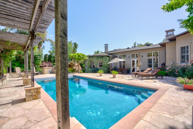 a view of swimming pool with outdoor seating and a patio