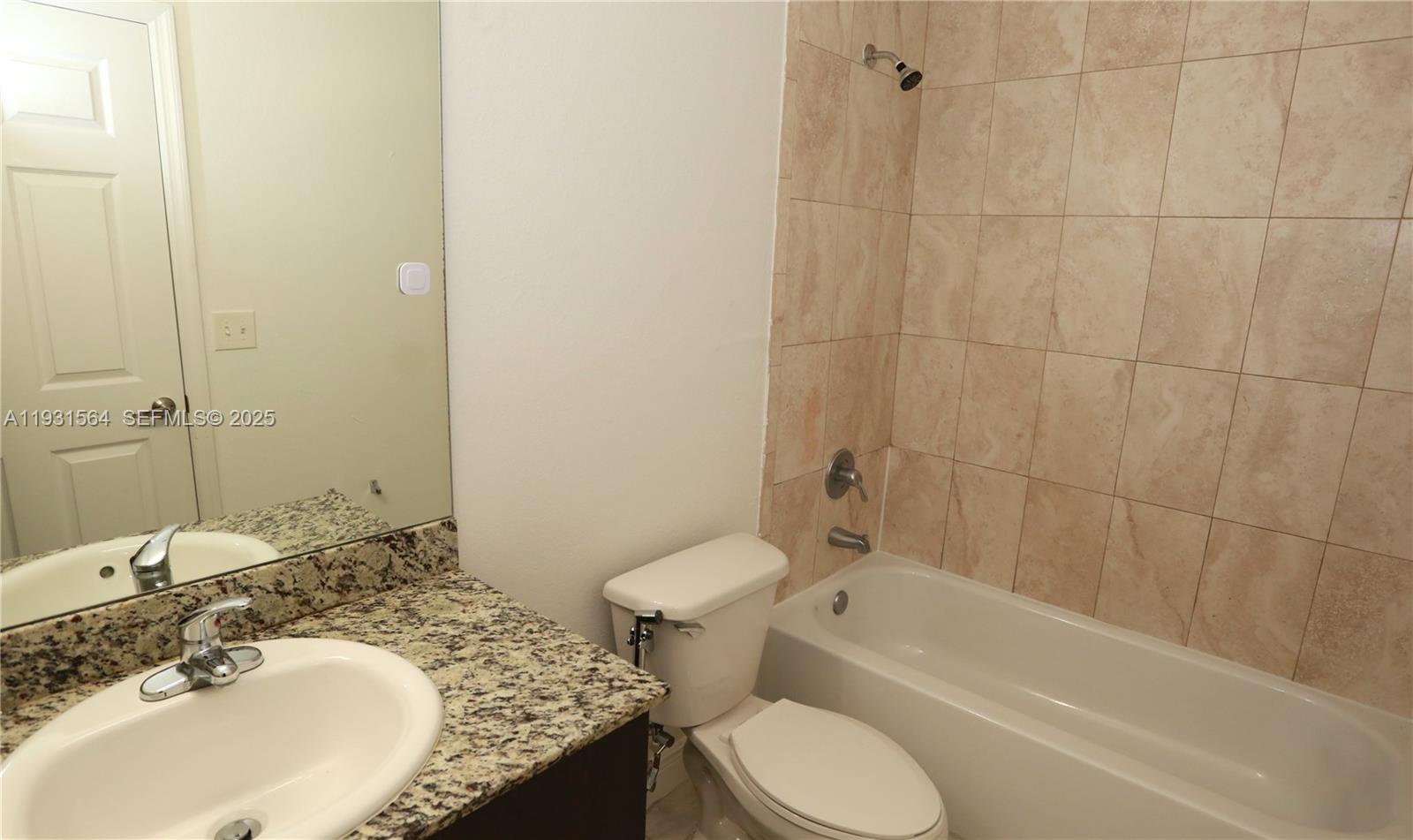 6151 Northwest 182nd Lane, Unit 301 Hialeah, FL 33015 - Photo 12 of 13 a bathroom with a granite countertop toilet sink and bathtub