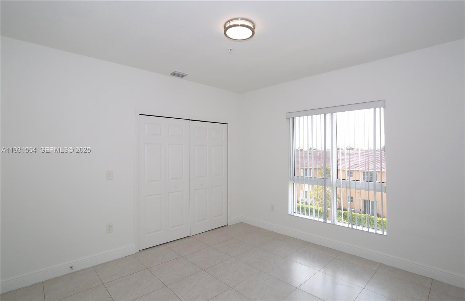 6151 Northwest 182nd Lane, Unit 301 Hialeah, FL 33015 - Photo 7 of 13 a view of an empty room with a window
