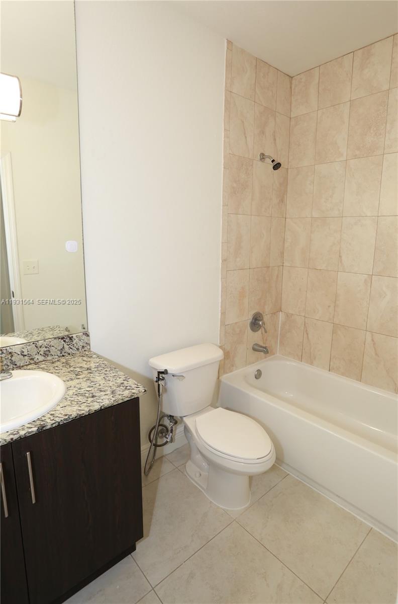 6151 Northwest 182nd Lane, Unit 301 Hialeah, FL 33015 - Photo 8 of 13 a bathroom with a granite countertop toilet a sink and a bathtub