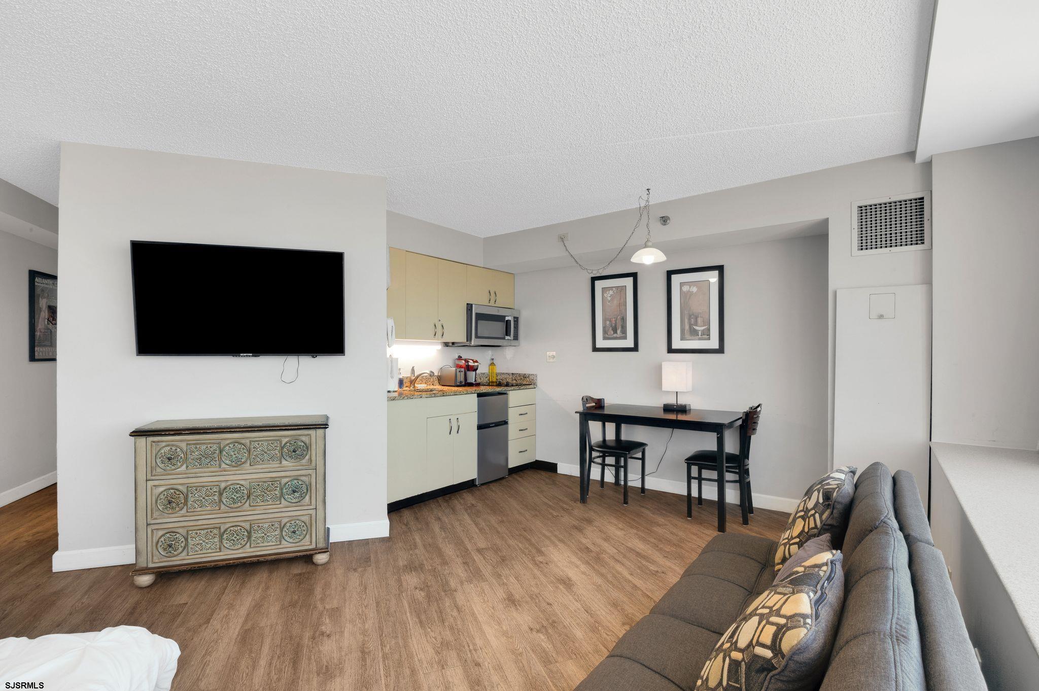 1515 Boardwalk, Unit 1004 Atlantic City, NJ 08401 - Photo 9 of 19 a living room with furniture a flat screen tv and kitchen view