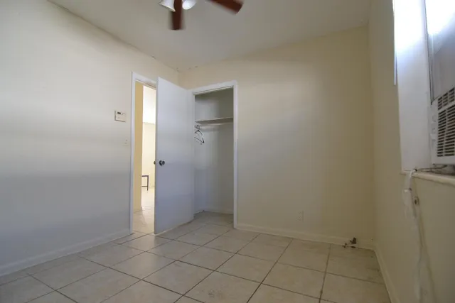 an empty room with closet and windows