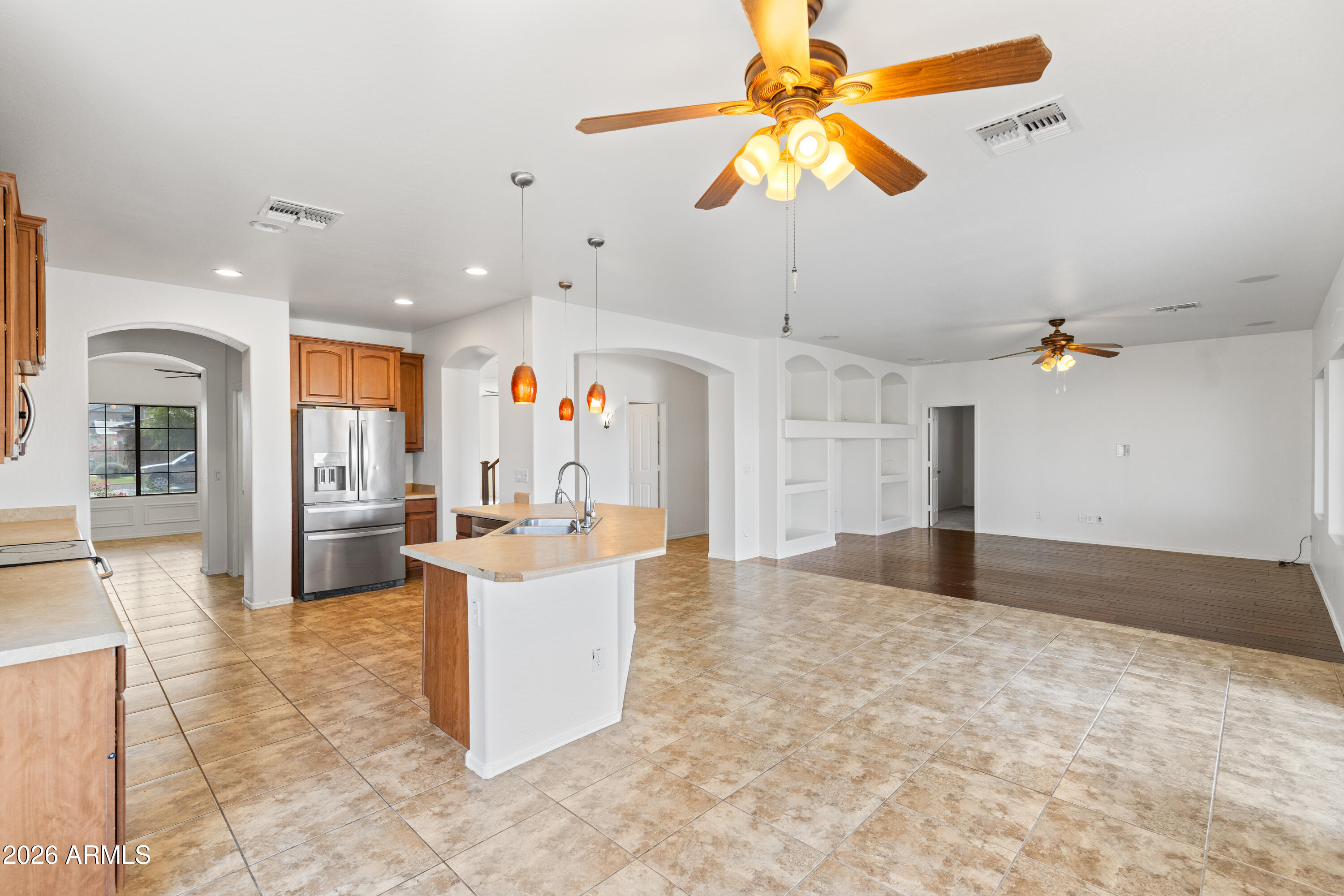 9840 Tangerine Road Florence, AZ 85132 - Photo 7 of 38 a living room with kitchen island furniture and a chandelier