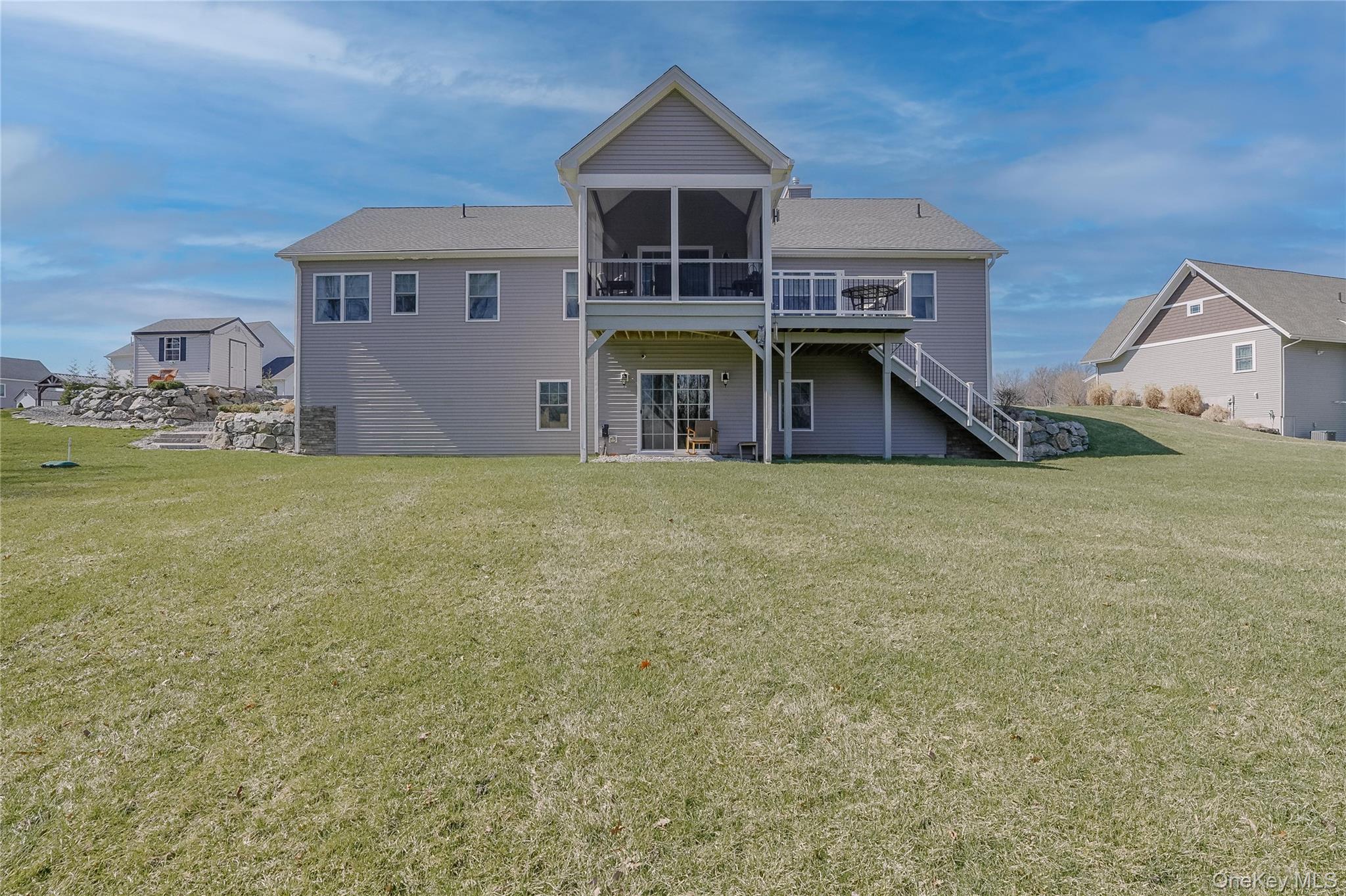 23 Swan Holw Road New Windsor, NY 12553 - Photo 21 of 28 The back of the home showcases a spacious deck and a screened-in porch, offering the perfect blend of open-air and covered outdoor living.
