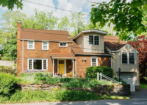 a front view of a house with a yard and potted plants