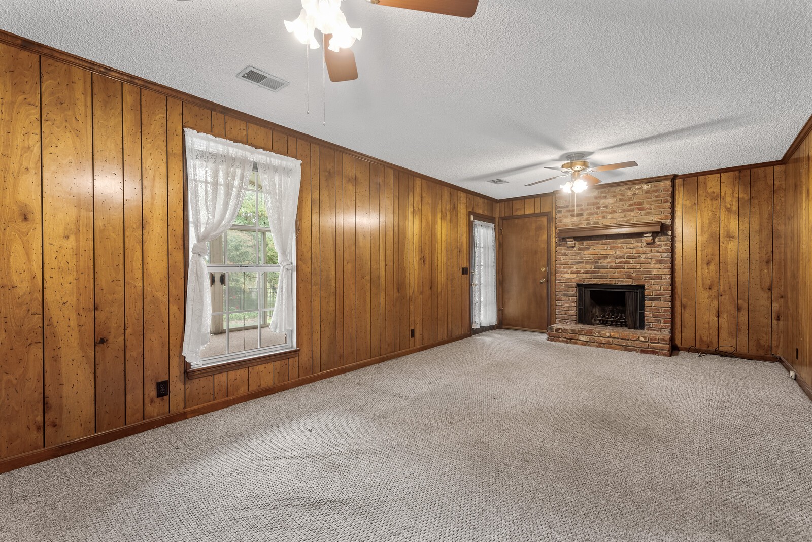 3352 Country Way Road Antioch, TN 37013 - Photo 8 of 26 an empty room with windows chandelier fan and a fireplace