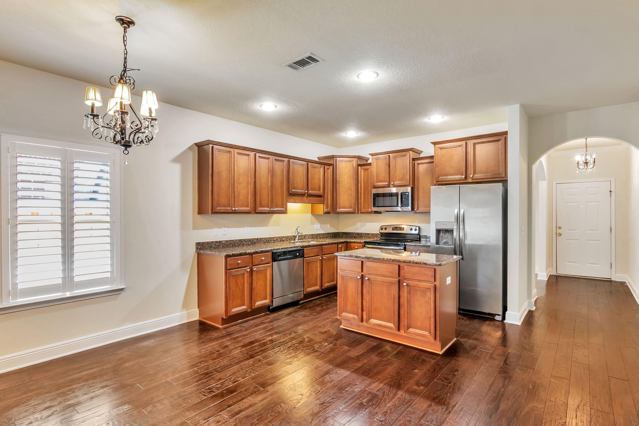 256 Cocobolo Drive Santa Rosa Beach, FL 32459 - Photo 15 of 45 a large kitchen with stainless steel appliances granite countertop a refrigerator a stove a sink dishwasher and white cabinets with wooden floor