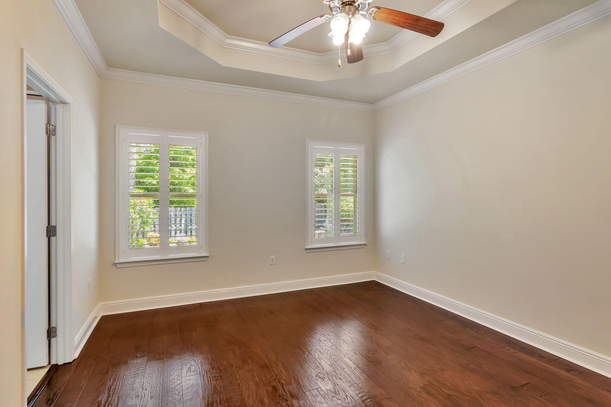 256 Cocobolo Drive Santa Rosa Beach, FL 32459 - Photo 22 of 45 an empty room with wooden floor chandelier fan and windows