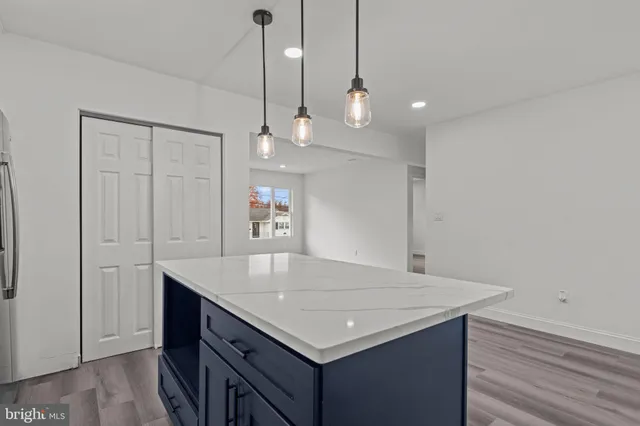 a kitchen with a stove a counter space and wooden floor