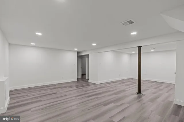 a view of an empty room with wooden floor