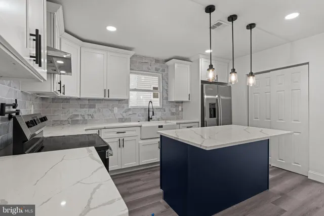 a kitchen with a sink a stove a refrigerator and white cabinets