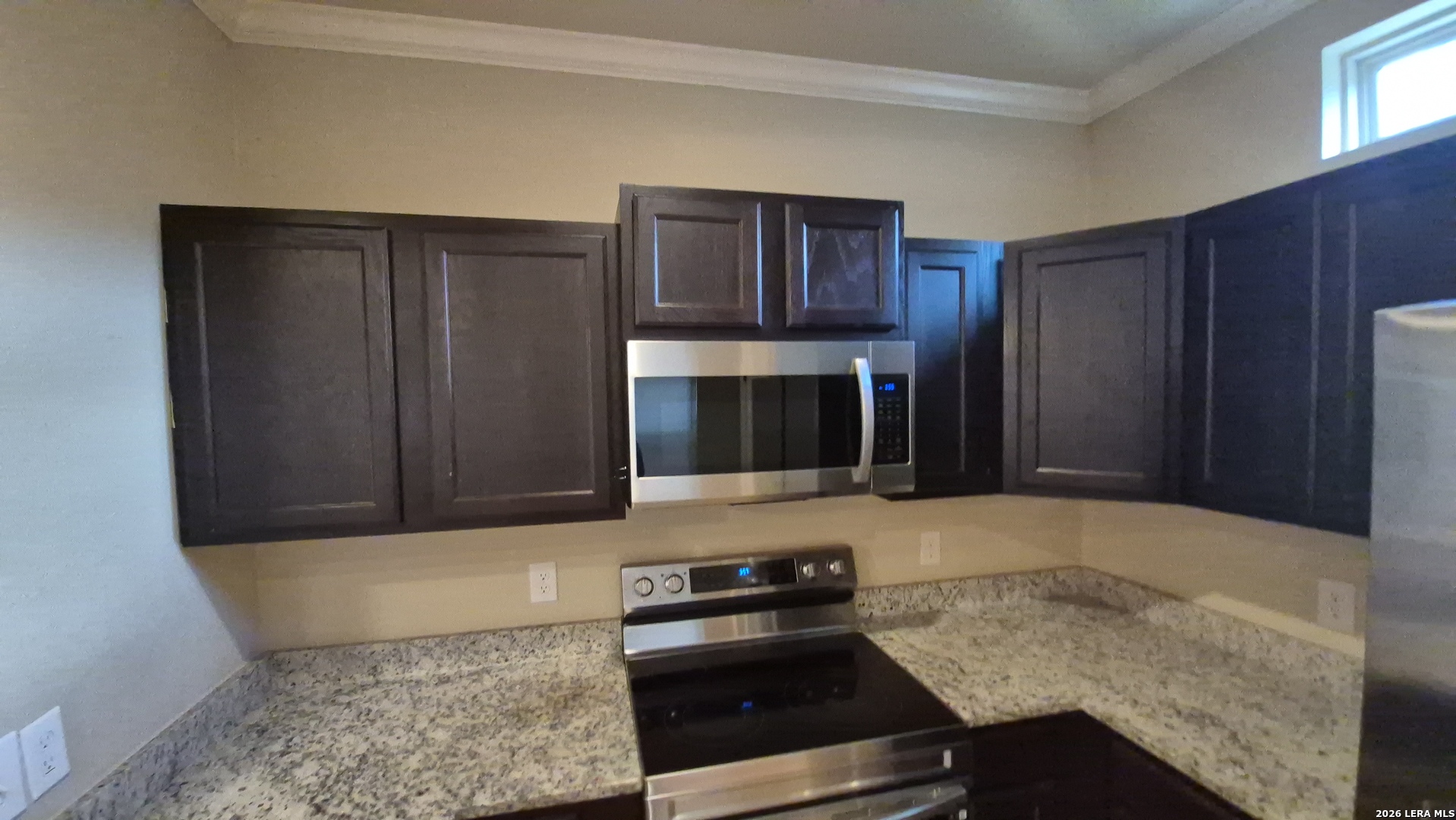 6414 Luglio Lane, Unit 101 San Antonio, TX 78233 - Photo 8 of 23 a kitchen with granite countertop stainless steel appliances and wooden cabinets