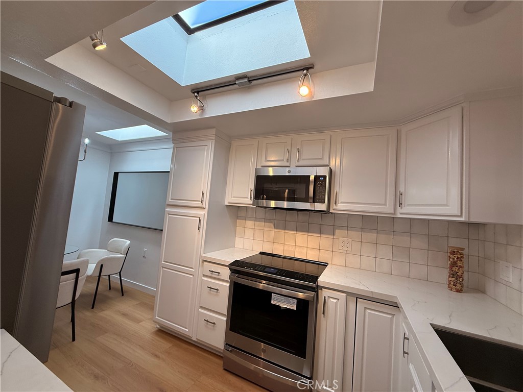 1921 St John Road, Unit 35C Seal Beach, CA 90740 - Photo 14 of 40 a kitchen with stainless steel appliances a stove microwave and sink