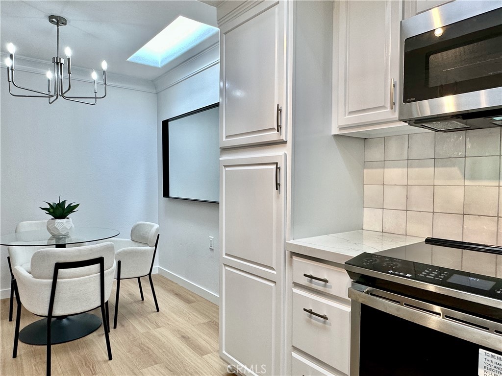 1921 St John Road, Unit 35C Seal Beach, CA 90740 - Photo 4 of 11 a kitchen with stainless steel appliances a white table and chairs in it