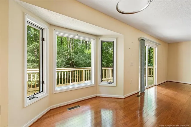 a view of an empty room with glass door and balcony