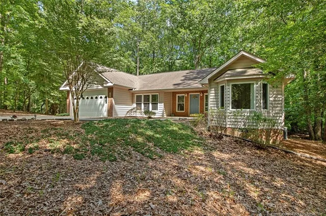 a front view of a house with yard and green space