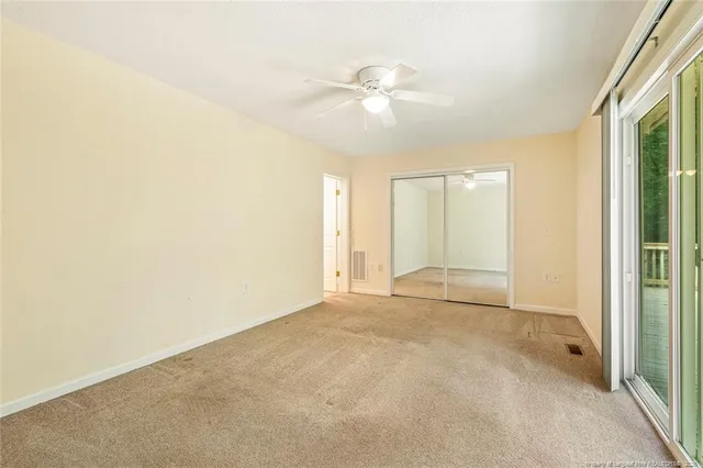 an empty room with fan and windows