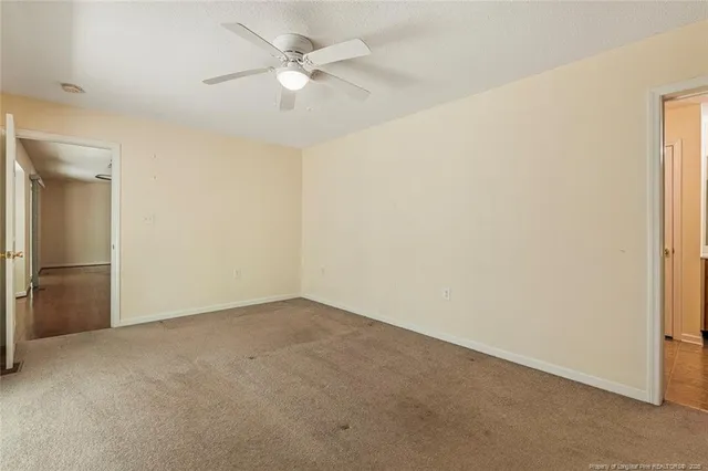 an empty room with a ceiling fan and a window