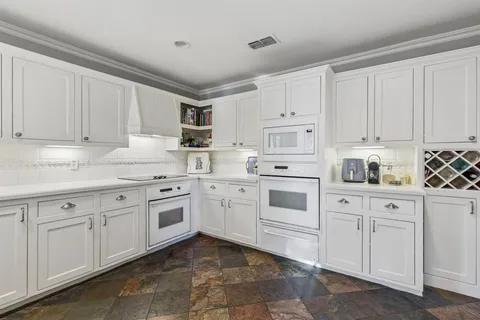 a kitchen with white cabinets white appliances and sink