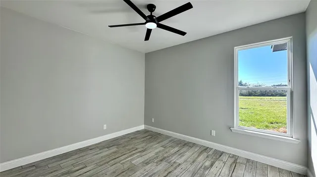 wooden floor in an empty room with a window
