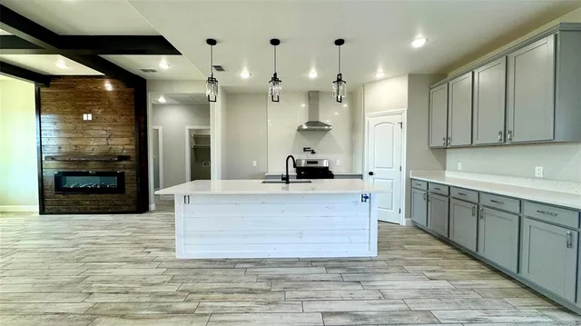 a large kitchen with kitchen island a sink stainless steel appliances and cabinets