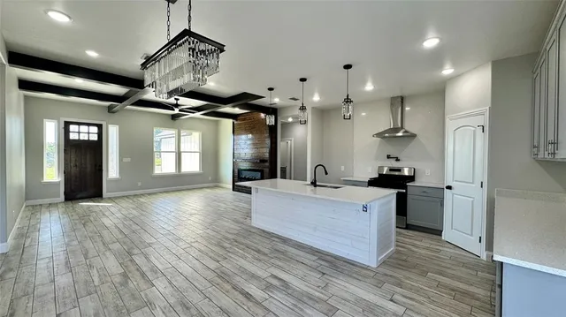 a large white kitchen with a large counter top space a sink and stainless steel appliances