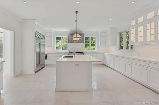 a kitchen with white cabinets and window