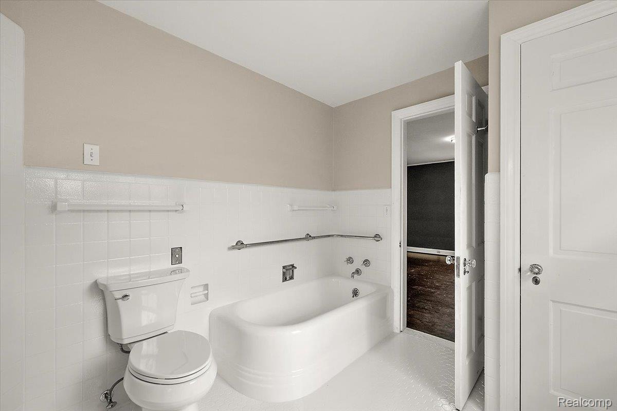 1051 Devonshire Road Grosse Pointe, MI 48230 - Photo 37 of 99 Bathroom featuring a white bathtub, white toilet, and white tile wainscoting