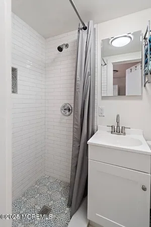 a bathroom with a sink a toilet a mirror and shower
