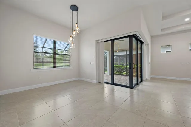 a view of a hallway with wooden floor and a flower garden