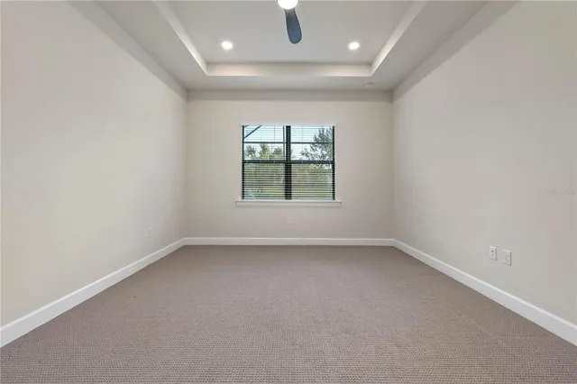 an empty room with a ceiling fan and closet area
