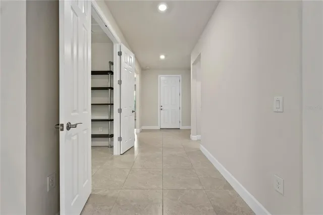 a front view of a house with a yard and potted plants