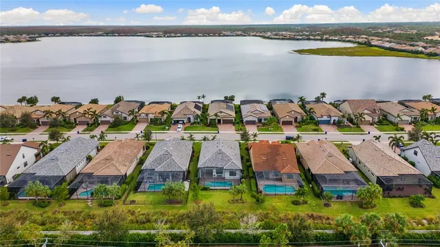 a view of swimming pool with a yard and palm trees