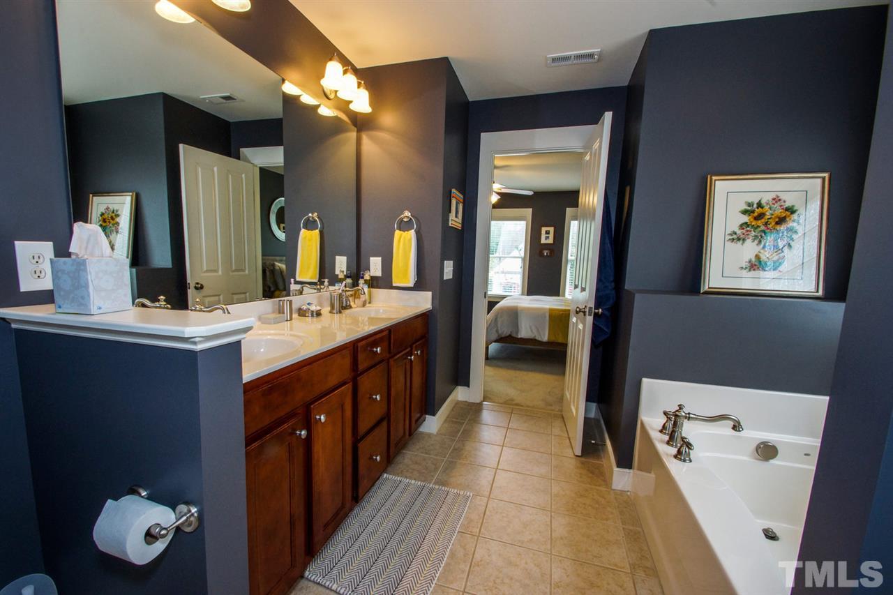 2244 Dunlin Lane Raleigh, NC 27614 - Photo 13 of 23 a spacious bathroom with a double vanity sink a large mirror and a bathtub