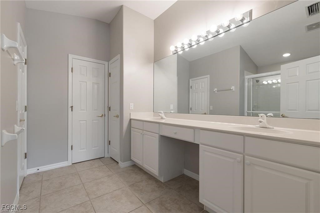 10074 Oakhurst Way Fort Myers, FL 33913 - Photo 13 of 32 a bathroom with a double vanity sink and a mirror