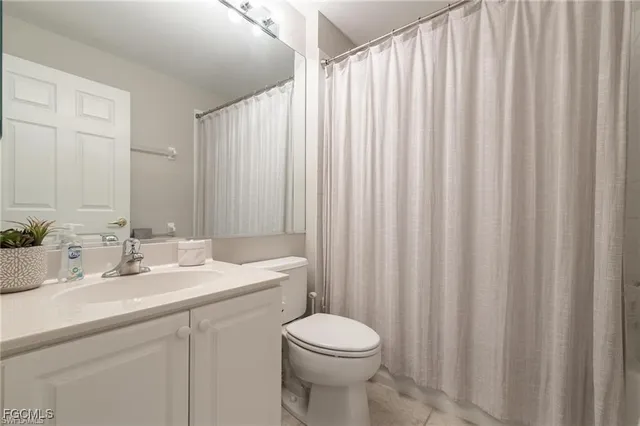 a bathroom with a sink a toilet and shower curtain