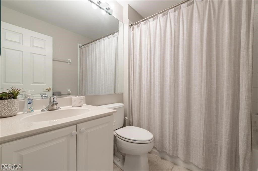 10074 Oakhurst Way Fort Myers, FL 33913 - Photo 14 of 32 a bathroom with a sink a toilet and shower curtain