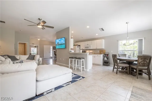 a living room with furniture a dining table and chairs with wooden floor
