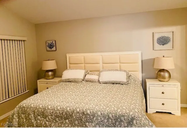 a bedroom with a bed and painting on the wall