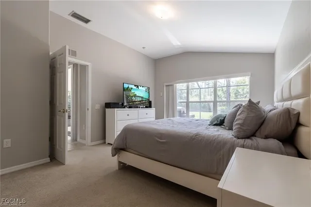 a bedroom with a bed and a flat tv screen on dresser