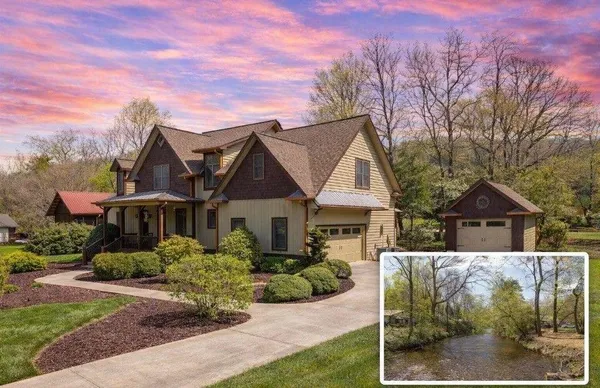 a view of a white house with a yard and potted plants