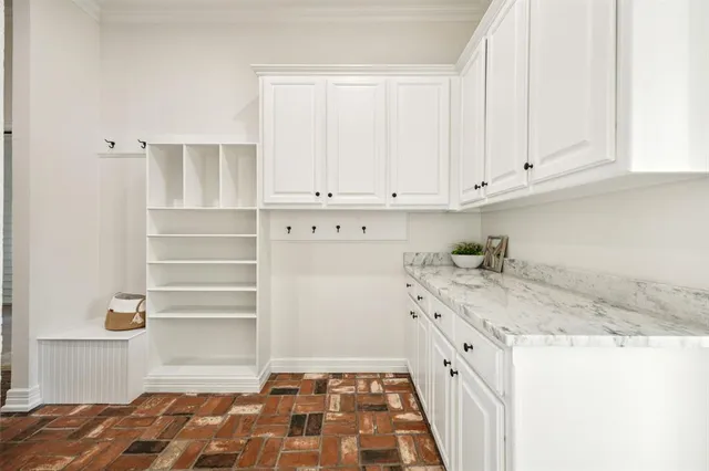 a kitchen with granite countertop white cabinets and sink