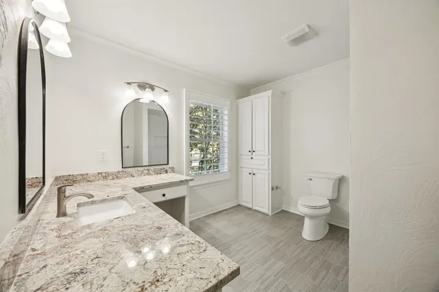 a large white room with a sink and mirror