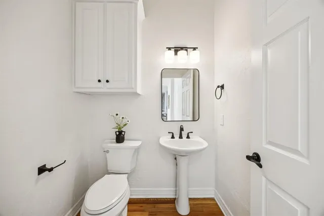 a bathroom with a sink toilet and a mirror