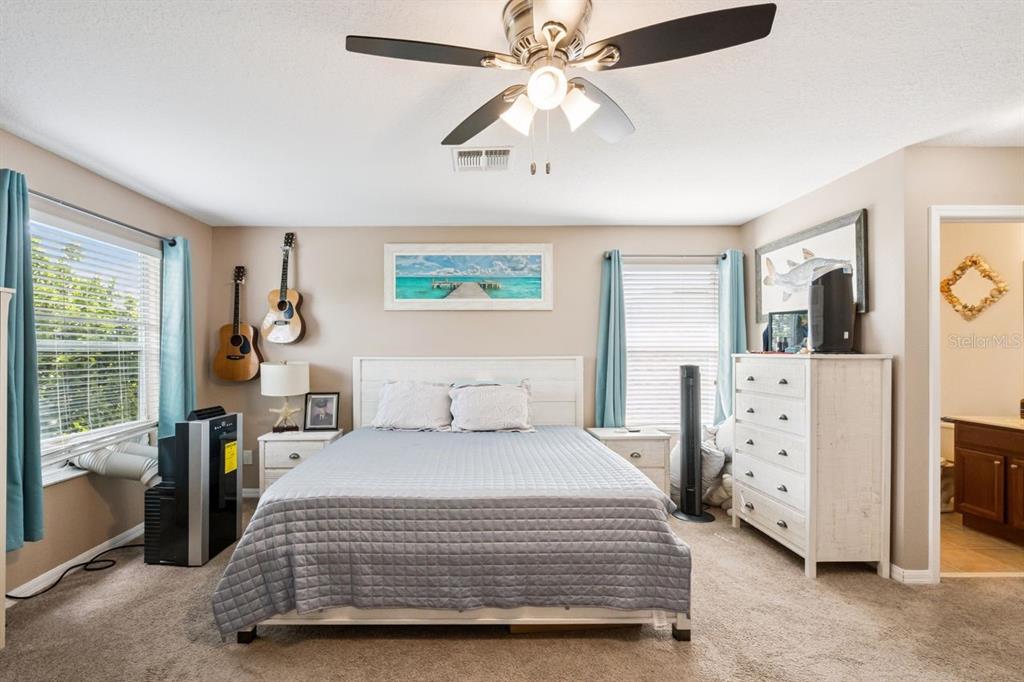 8484 Dover View Lane Orlando, FL 32829 - Photo 18 of 41 a bedroom with a large bed and a chandelier