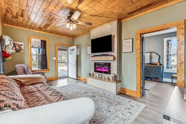 a living room with furniture a flat screen tv and a fireplace