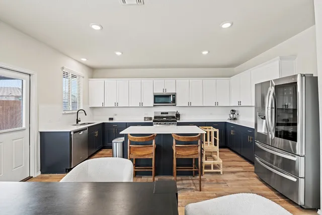 a large kitchen with kitchen island a large counter top space appliances and cabinets