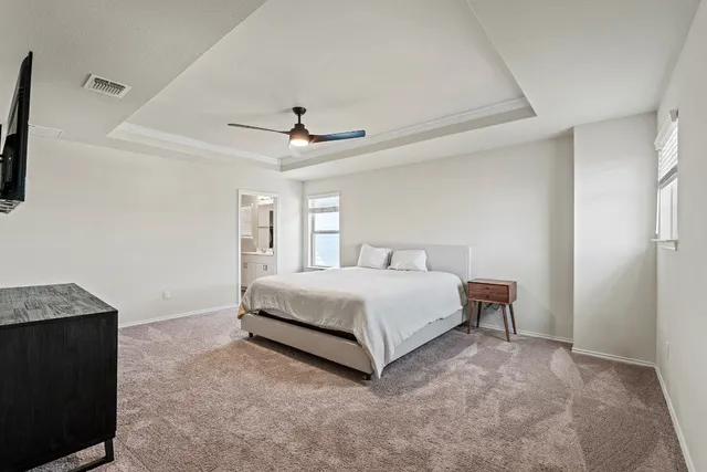 a spacious bedroom with a bed and a ceiling fan