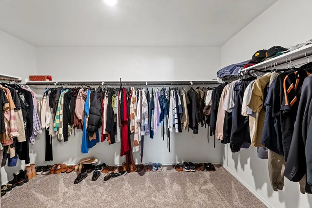 a view of walk in closet with clothes