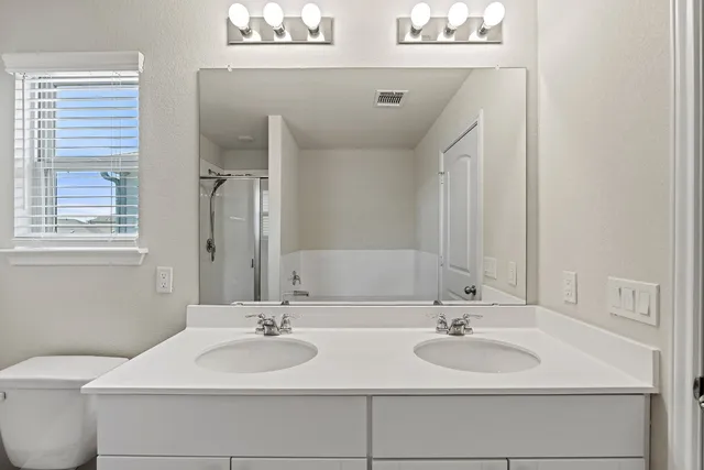 a bathroom with 2 sink and a mirror